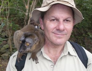 Photo of author Alan Dean Foster with a lemur on his shoulder.